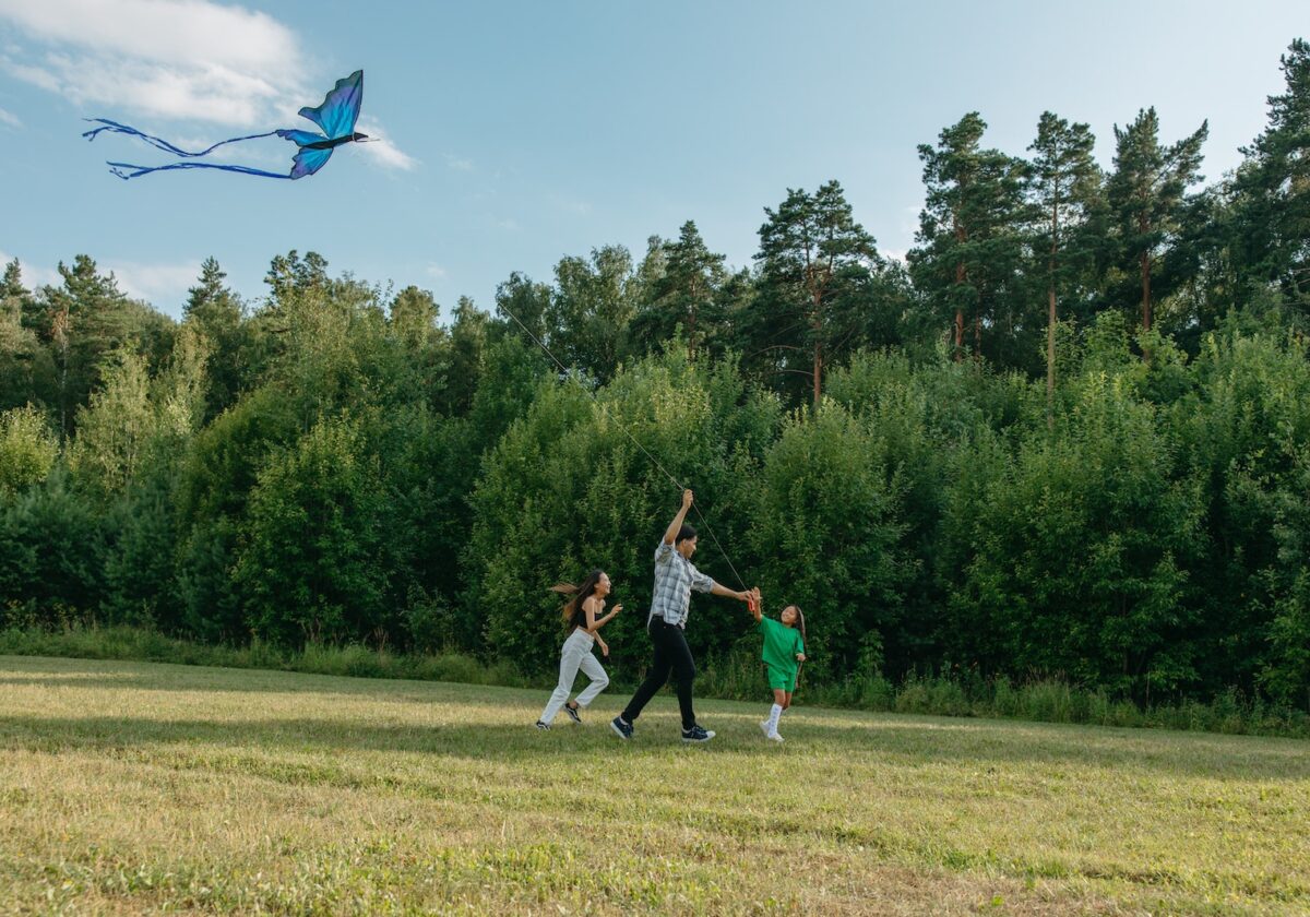 Photo of a Family Playing with a Kite Together