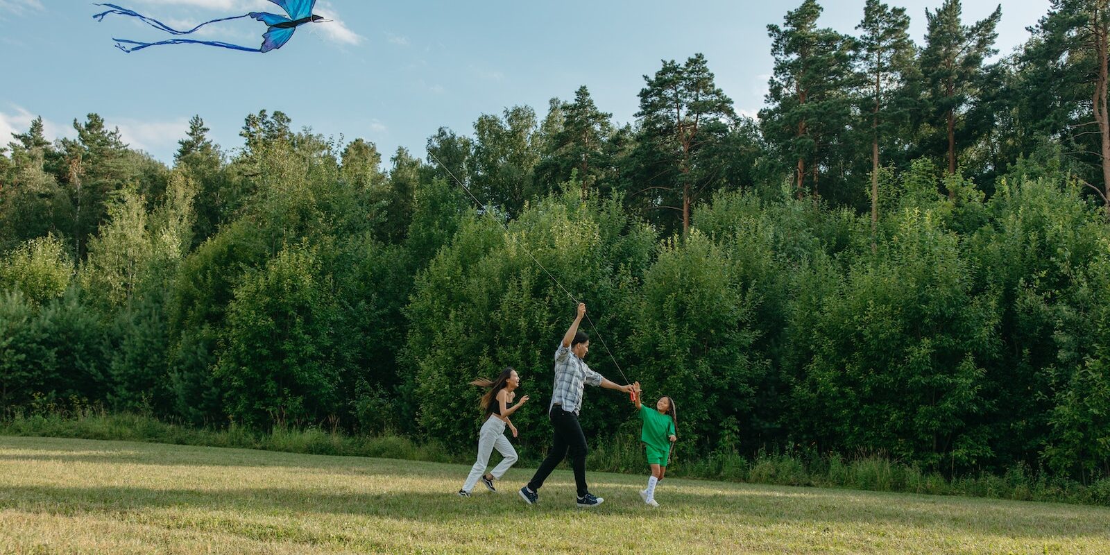 Photo of a Family Playing with a Kite Together